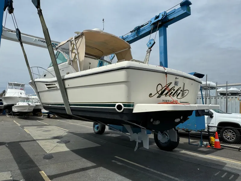 Slide: The Image of 2001 Pursuit 3000 Express boat lifted at marina, showcasing hull and design. - 25
