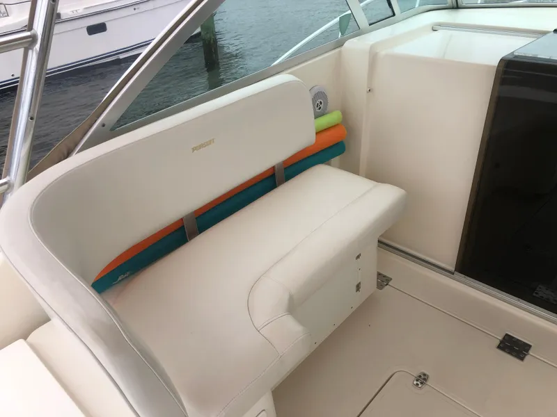 Slide: The Image of 2001 Pursuit 3000 Express boat interior with white seating and colorful cushions. - 28