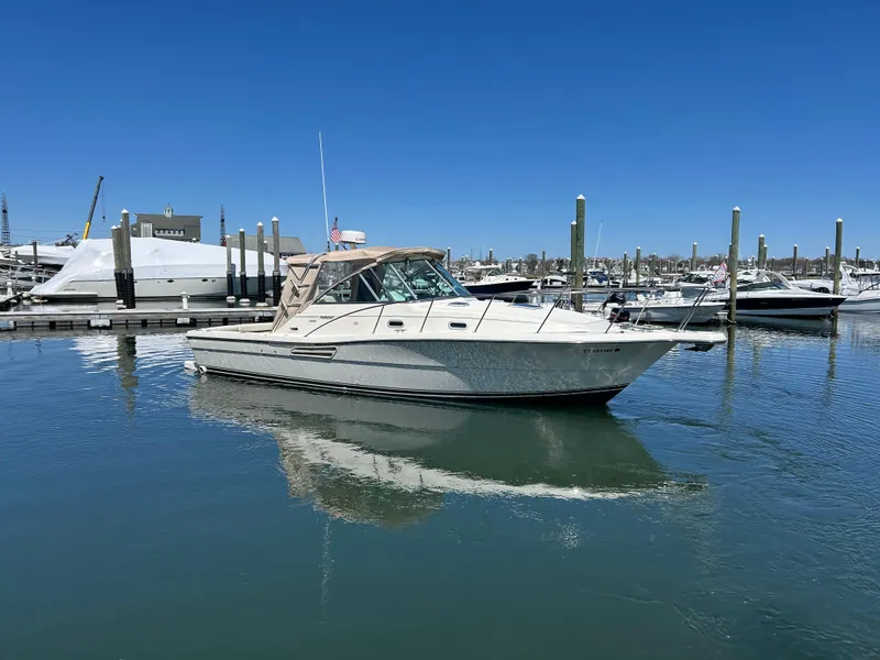 Slide: The Image of 2001 Pursuit 3000 Express boat docked in a marina under clear blue skies. - 3