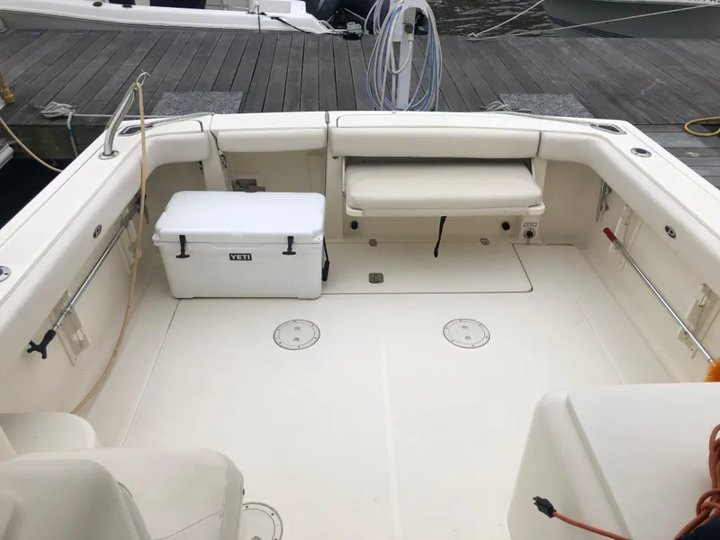 Slide: The Image of 2001 Pursuit 3000 Express boat deck with seating and cooler, docked at marina. - 30