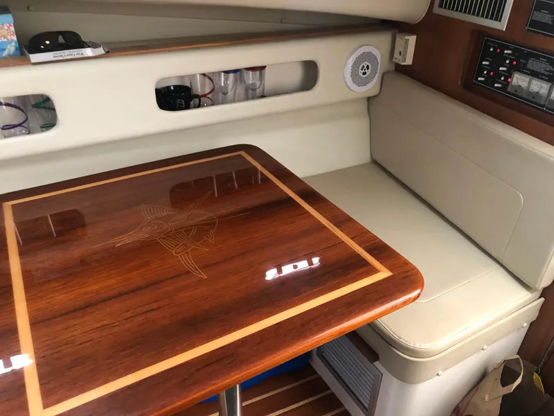 Slide: The Image of 2001 Pursuit 3000 Express cabin with wooden table and cushioned seating. - 33