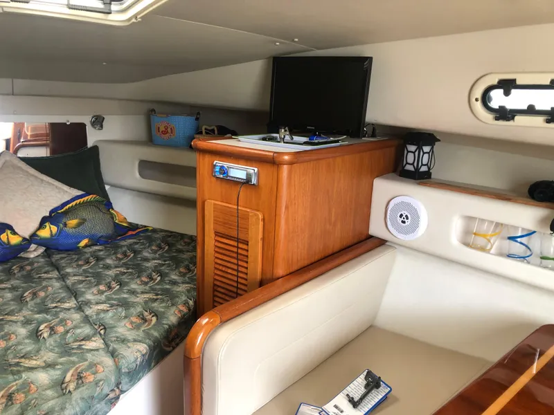 Slide: The Image of Interior of a 2001 Pursuit 3000 Express boat with cozy seating and a small TV. - 35