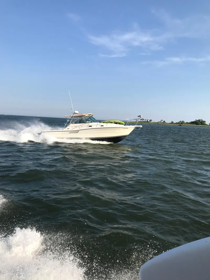 Slide: The Image of 2001 Pursuit 3000 Express boat cruising on open water under clear blue sky. - 37