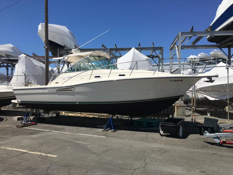 Slide: The Image of 2001 Pursuit 3000 Express boat on dry dock, surrounded by other covered boats. - 43