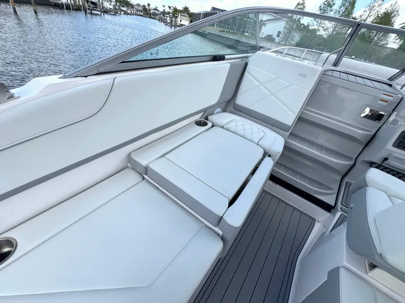 Slide: The Image of 2024 Regal 26 XO boat interior with white seating and sleek design by the water. - 14