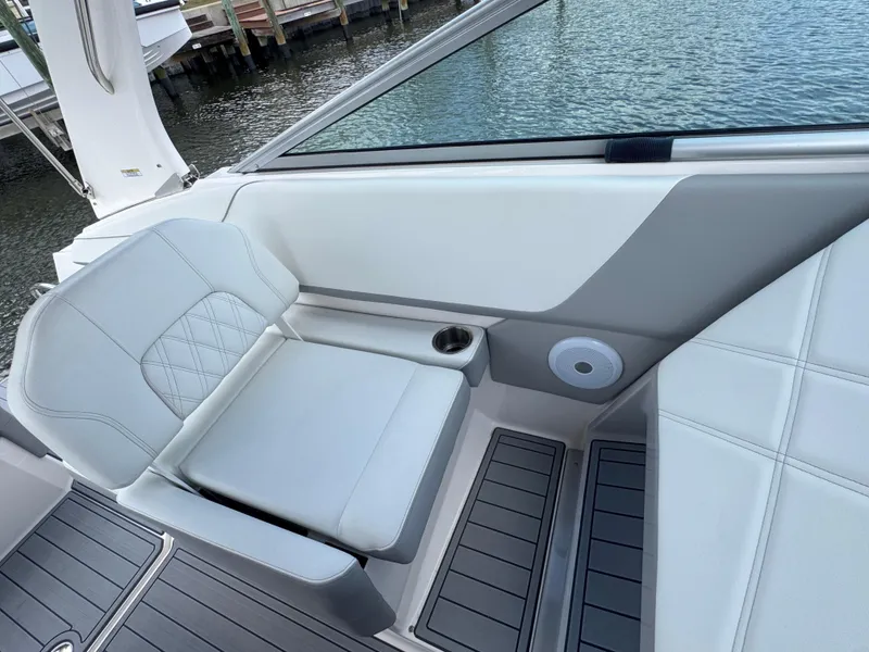 Slide: The Image of 2024 Regal 26 XO boat interior with white seating and cup holder by the water. - 18