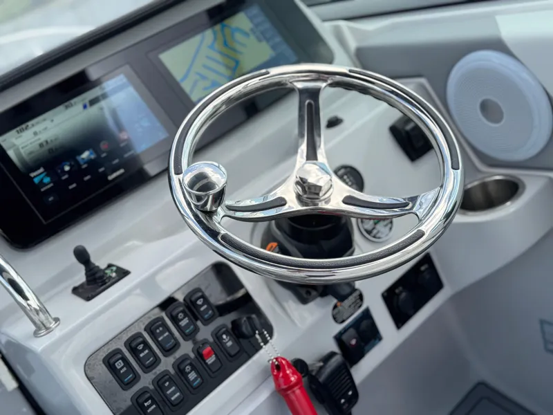Slide: The Image of 2024 Regal 26 XO boat dashboard with steering wheel and control panel. - 20