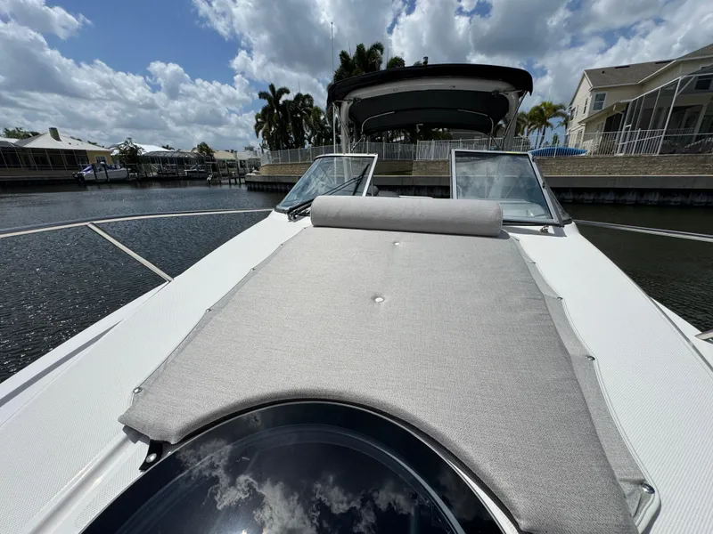 Slide: The Image of 2024 Regal 26 XO boat with sunpad, docked in a scenic marina. - 24