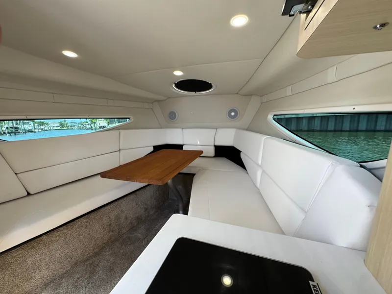 Slide: The Image of 2024 Regal 26 XO cabin interior with white seating and wooden table. - 25