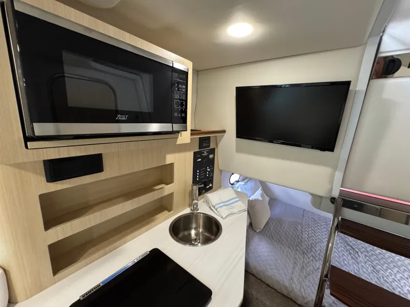 Slide: The Image of 2024 Regal 26 XO cabin interior with microwave, sink, and TV. - 27