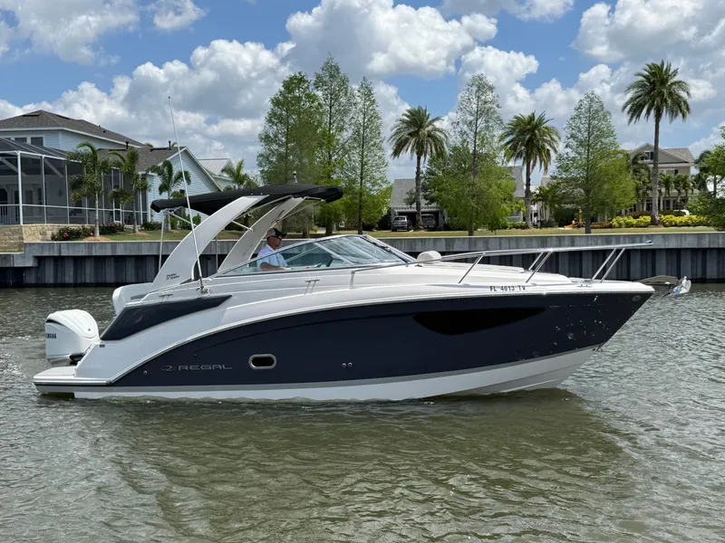 Slide: The Image of 2024 Regal 26 XO boat cruising on a sunny day with palm trees in the background. - 3