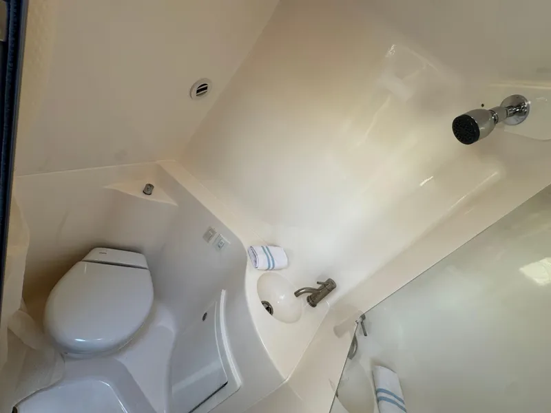 Slide: The Image of 2024 Regal 26 XO boat bathroom with toilet, sink, and showerhead. - 31