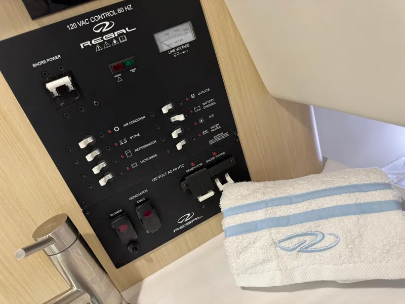 Slide: The Image of 2024 Regal 26 XO control panel with towel, showcasing boat's electrical system. - 34