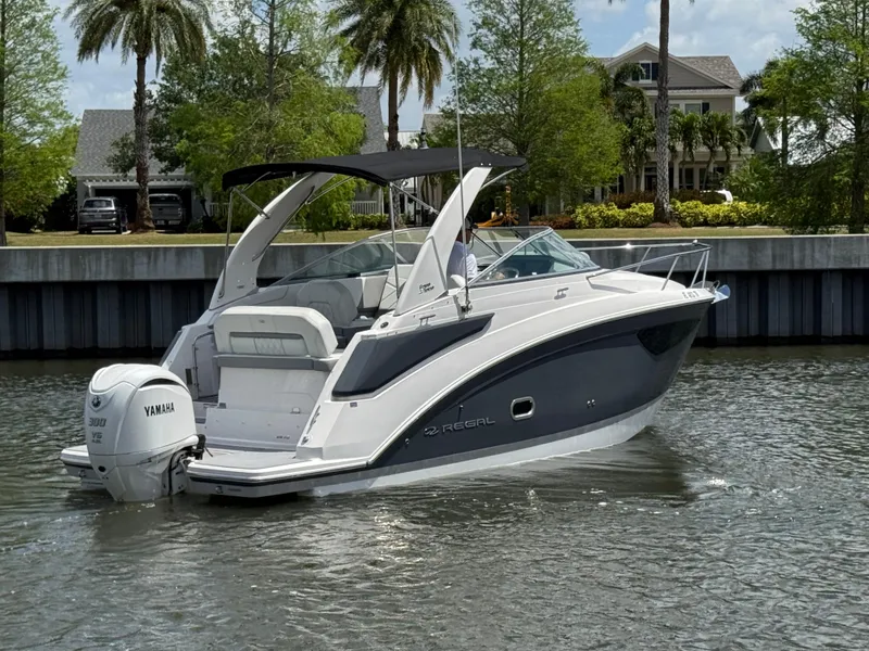 Slide: The Image of 2024 Regal 26 XO boat with Yamaha engine on a calm waterway. - 4