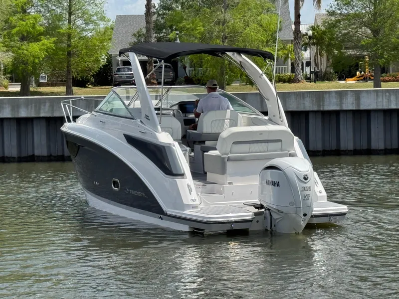 Slide: The Image of 2024 Regal 26 XO boat with Yamaha engine, cruising on a calm waterway. - 6