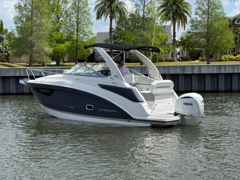 Slide: The Image of 2024 Regal 26 XO boat with Yamaha engine on a calm waterway. - 7