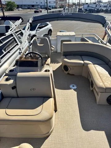 Slide: The Image of 2022 Avalon VTX1880QF pontoon boat with beige seating and steering console, docked outdoors. - 6