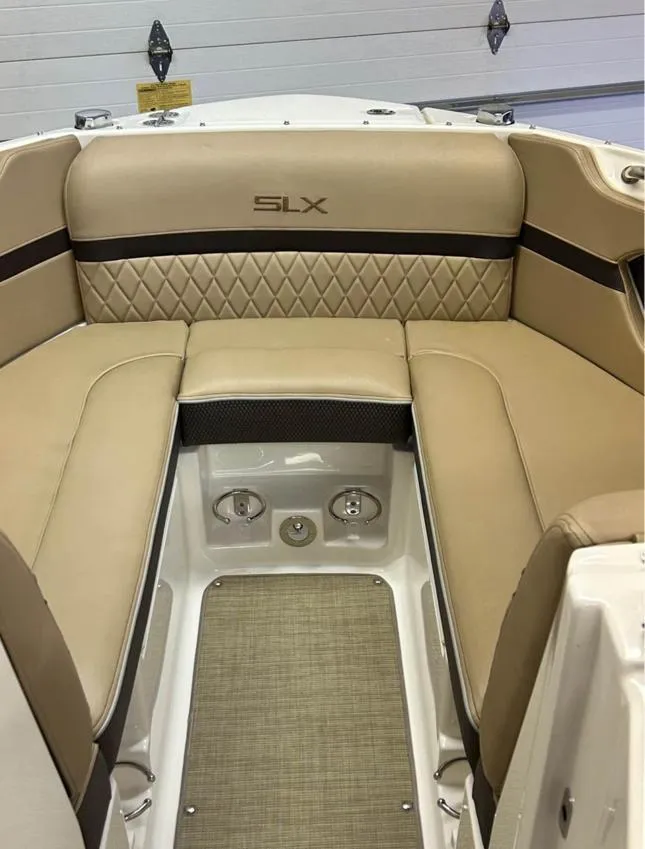 Slide: The Image of 2016 Sea Ray SLX 230 boat interior with beige seating and SLX logo. - 2