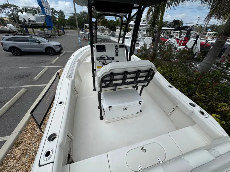 Slide: The Image of 2025 Key West 219 FS boat interior with seating and console, parked in a marina. - 11