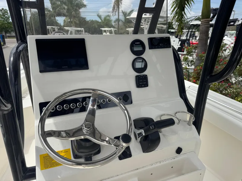 Slide: The Image of 2025 Key West 219 FS boat dashboard with steering wheel and control panel. - 17