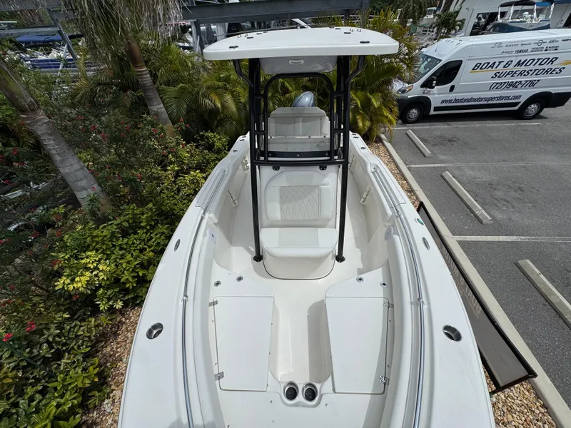 Slide: The Image of 2025 Key West 219 FS boat, top view, parked near tropical plants and a service van. - 23