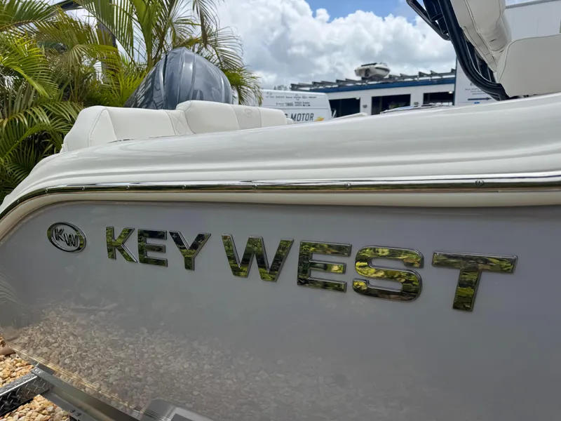 Slide: The Image of 2025 Key West 219 FS boat side view with logo, tropical setting. - 4