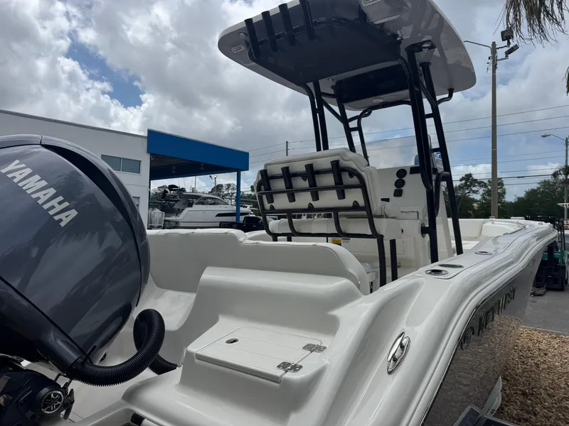 Slide: The Image of 2025 Key West 219 FS boat with Yamaha engine, parked outdoors under cloudy sky. - 5