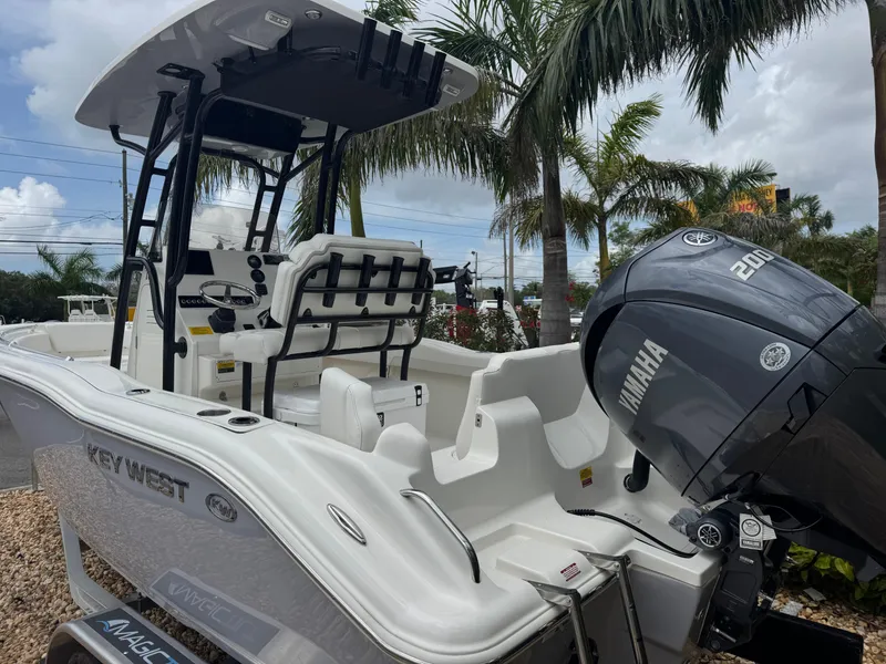 Slide: The Image of 2025 Key West 219 FS boat with Yamaha engine, parked outdoors near palm trees. - 7