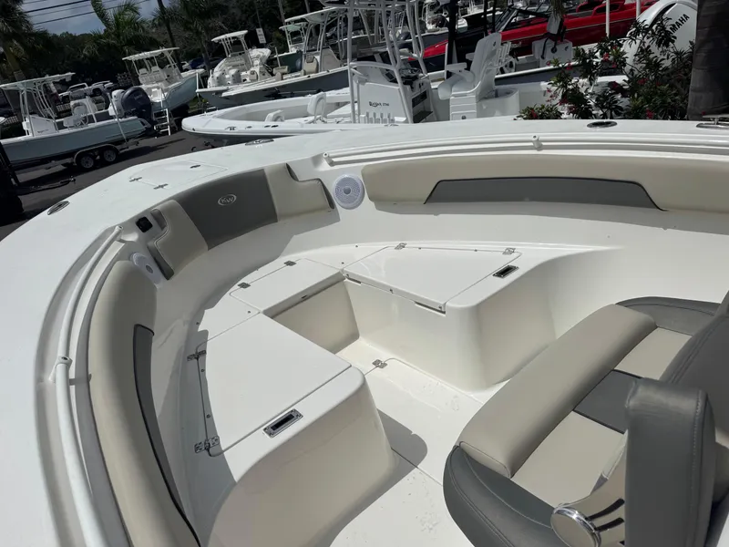 Slide: The Image of 2025 Key West 260 boat interior with seating and storage, docked among other boats. - 18