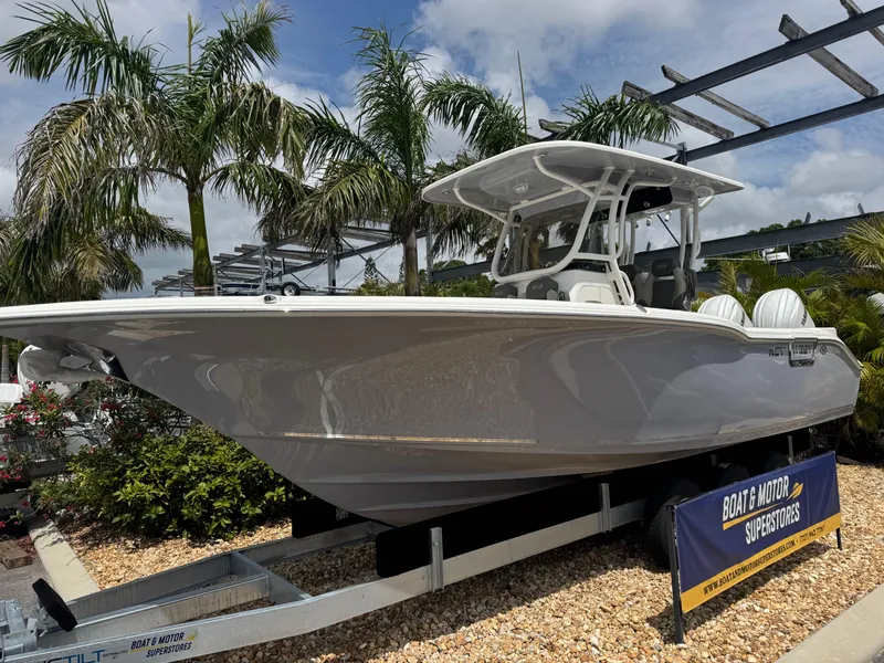 Slide: The Image of 2025 Key West 260 boat displayed outdoors with palm trees in the background. - 2