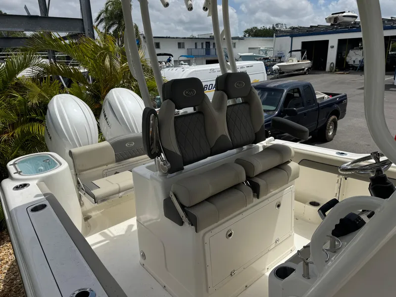 Slide: The Image of 2025 Key West 260 boat interior with dual seats and twin engines, parked outdoors. - 29