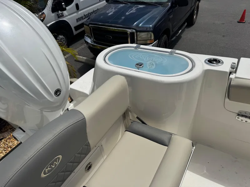 Slide: The Image of 2025 Key West 260 boat interior with seating and livewell, parked near vehicles. - 33