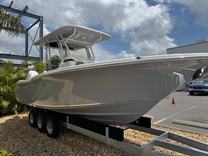 Slide: The Image of 2025 Key West 260 boat on trailer, parked outdoors under a partly cloudy sky. - 4