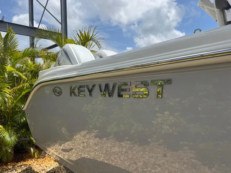 Slide: The Image of 2025 Key West 260 boat side view with logo, surrounded by tropical plants. - 6
