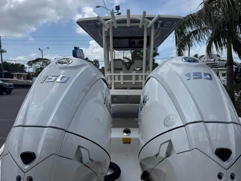 Slide: The Image of 2025 Key West 260 boat with dual 150 horsepower engines, docked under a cloudy sky. - 8