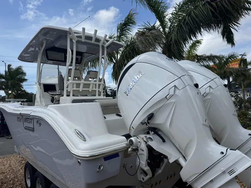 Slide: The Image of 2025 Key West 260 boat with dual Yamaha engines, parked near palm trees. - 9