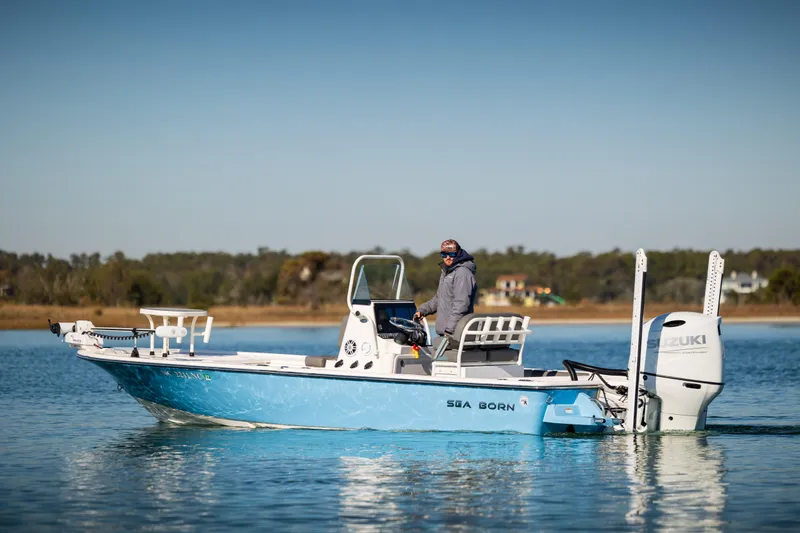 Slide: The Image of 2024 Sea Born FX22 Bay boat on calm water with a person onboard. - 0