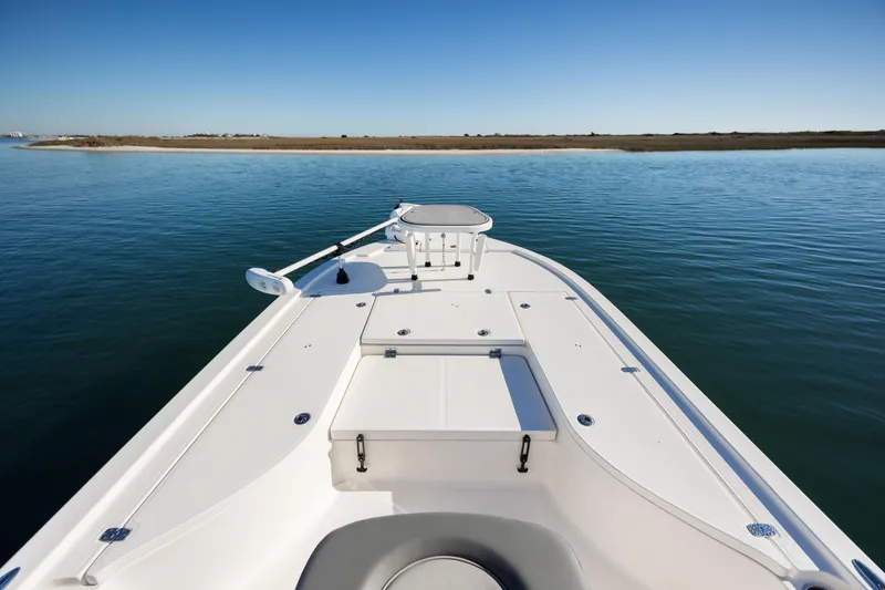 Slide: The Image of 2024 Sea Born FX22 Bay boat on calm water, showcasing spacious deck and sleek design. - 10