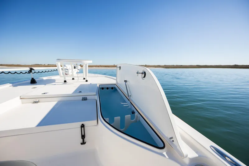 Slide: The Image of 2024 Sea Born FX22 Bay boat with open storage compartment on calm water. - 12