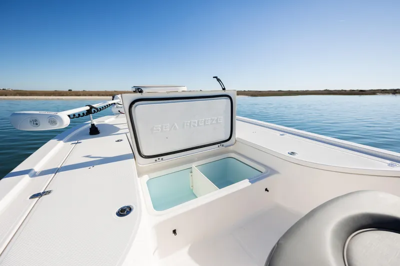 Slide: The Image of 2024 Sea Born FX22 Bay boat with open storage compartment on calm water. - 13