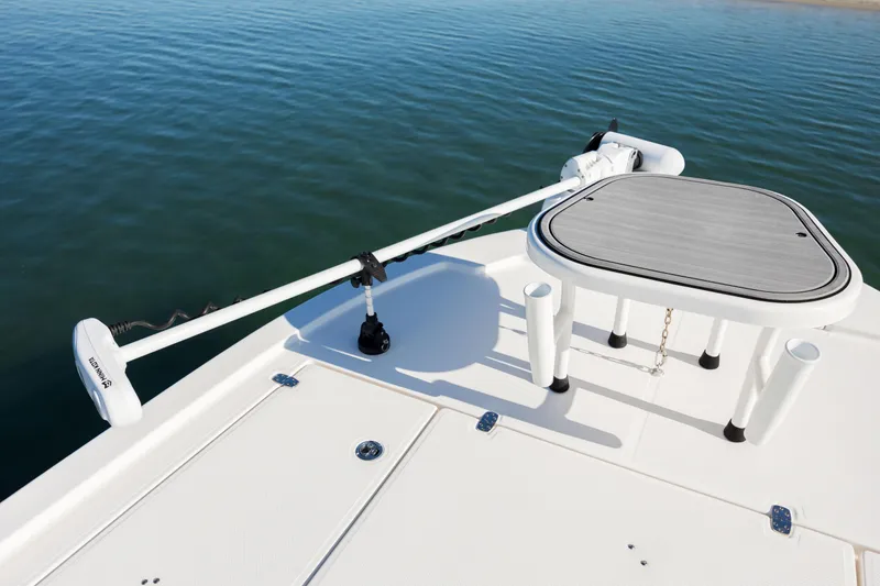 Slide: The Image of 2024 Sea Born FX22 Bay boat deck with trolling motor and table on calm water. - 14