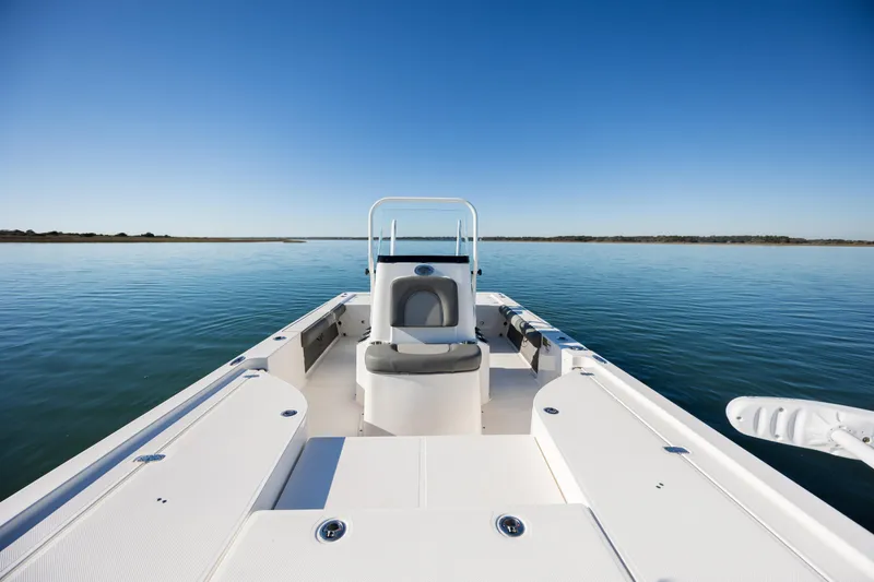 Slide: The Image of 2024 Sea Born FX22 Bay boat on calm water under clear blue sky. - 18