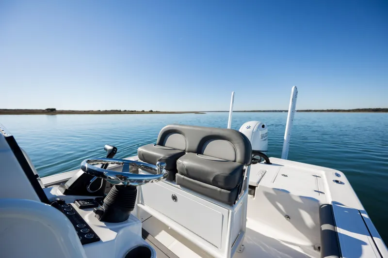 Slide: The Image of 2024 Sea Born FX22 Bay boat on calm water, featuring sleek seating and steering console. - 21