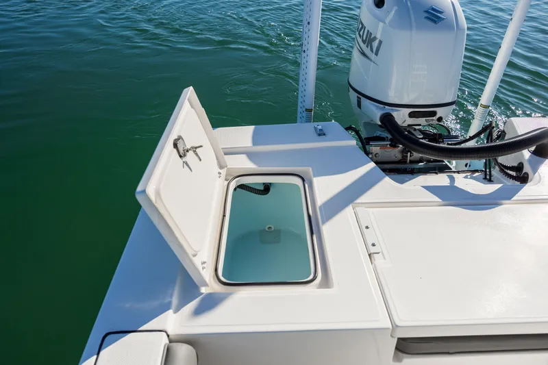 Slide: The Image of 2024 Sea Born FX22 Bay boat with open storage compartment and Suzuki outboard motor. - 27