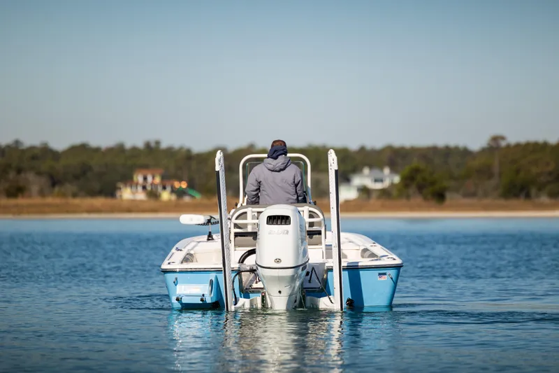 Slide: The Image of 2024 Sea Born FX22 Bay boat on calm water, rear view. - 7