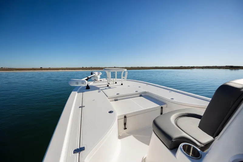Slide: The Image of 2024 Sea Born FX22 Bay boat on calm water under clear blue sky. - 9
