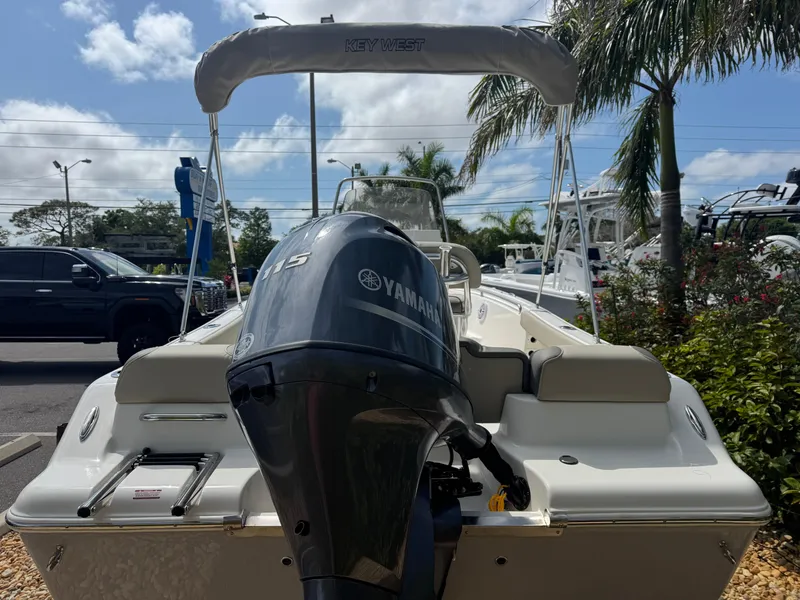 Slide: The Image of 2025 Key West 189 FS boat with Yamaha engine, parked outdoors under a clear sky. - 11