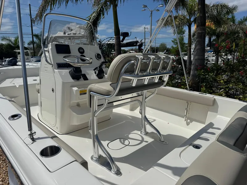 Slide: The Image of 2025 Key West 189 FS boat interior with console and seating, surrounded by palm trees. - 14