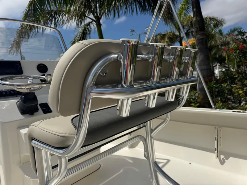 Slide: The Image of 2025 Key West 189 FS boat interior with rod holders and seating, surrounded by tropical foliage. - 15