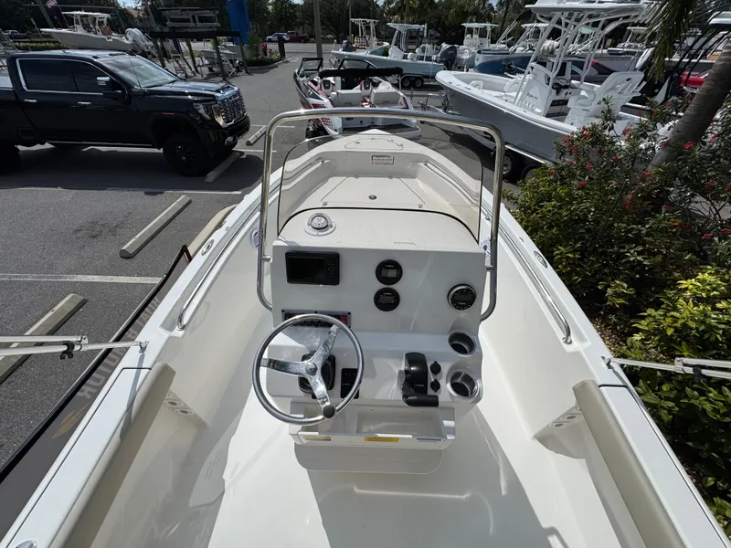 Slide: The Image of 2025 Key West 189 FS boat interior with steering console, parked in a marina. - 18
